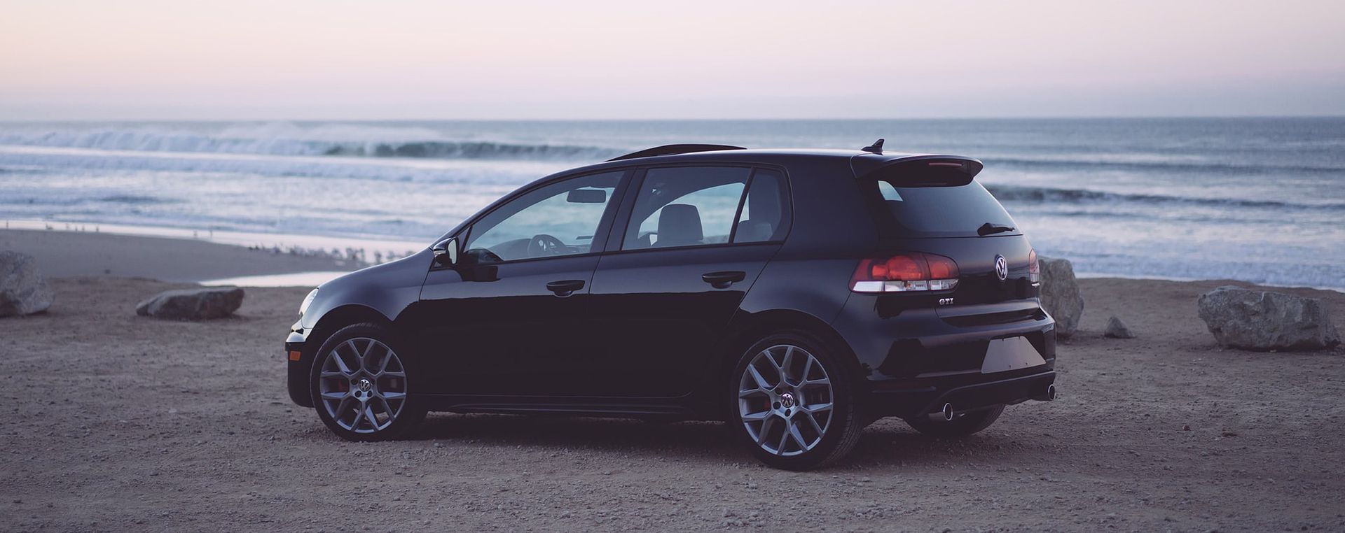 Ein schwarzes Auto am Strand von der Marke Volkswagen